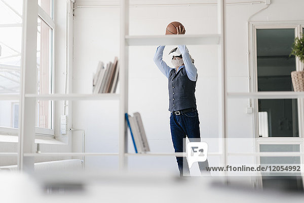 Erwachsener Mann mit VR-Brille beim Basketballspielen im Büro