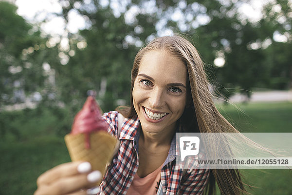 Portrait of happy young woman holding ice cream cone