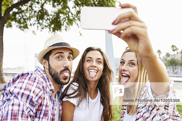 Three friends taking a selfie sticking tongues out