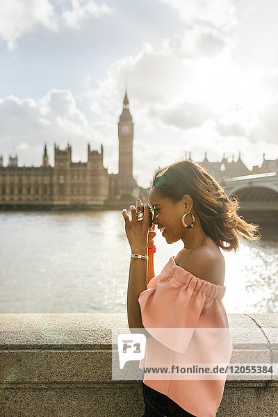 UK  London  beautiful woman taking a picture near Westminster Bridge