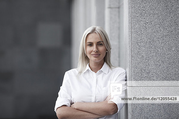 Portait of confident businesswoman leaning against a wall