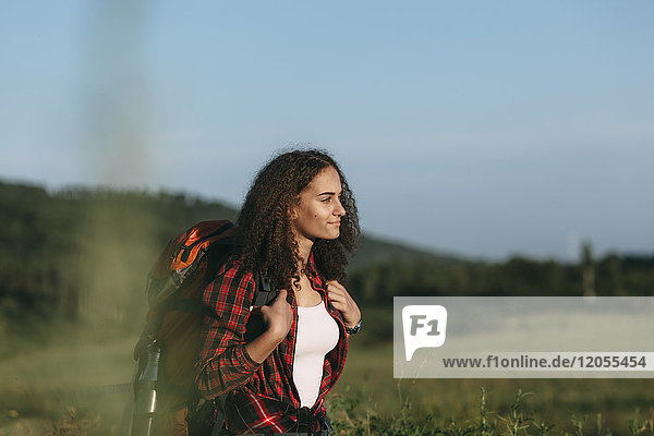 Teenage girl with backpack hiking in nature