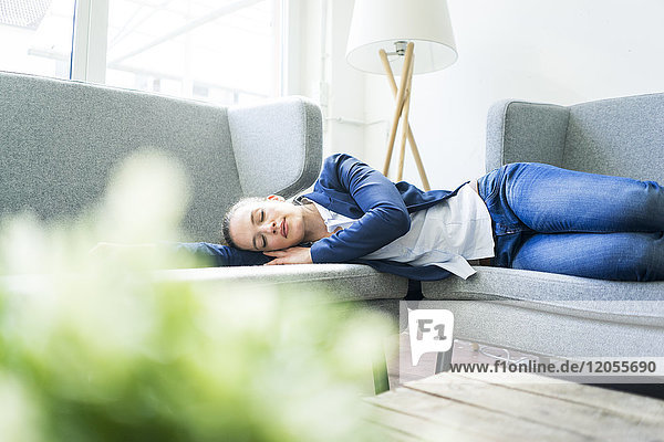 Businesswoman lying on couch sleeping