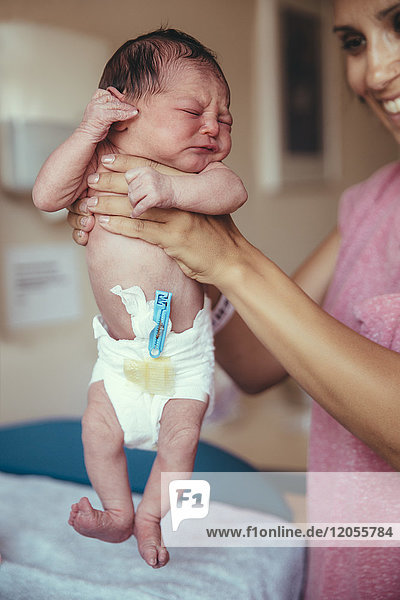 Neugeborenes Mädchen im Krankenhaus mit den Händen der Mutter