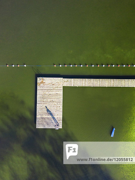 Luftaufnahme eines Mannes am Steg eines Sees
