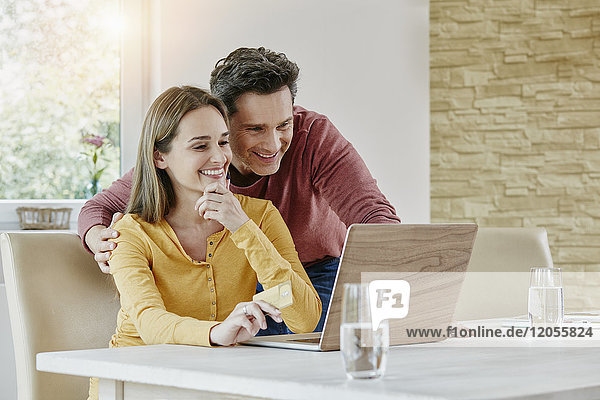 Happy couple at home shopping online