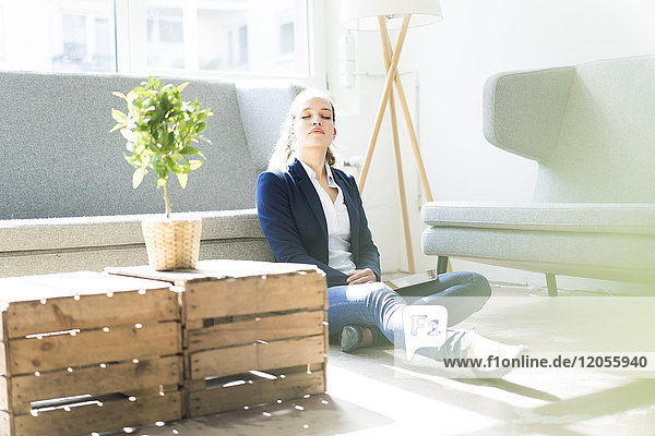 Businesswoman sitting on the floor relaxing
