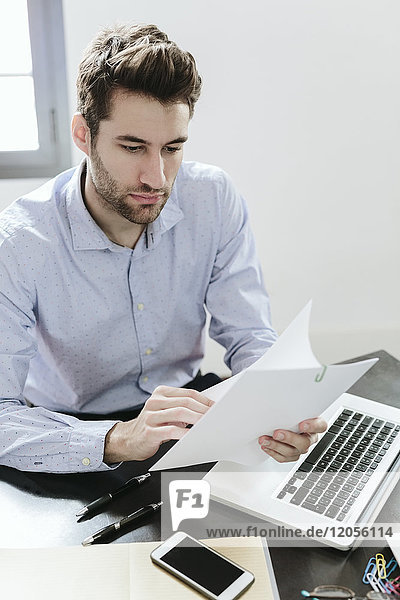 Young businessman working in office  reading documents
