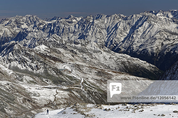 Österreich Tirol Ötztal Sölden Frau in schneebedeckter Landschaft mit Blick auf die Ötztaler Gletscherstraße