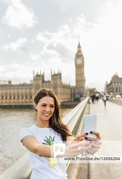 UK  London  schöne Frau  die einen Selfie auf der Westminster Bridge nimmt.