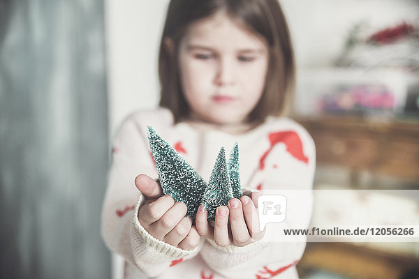Kleines Mädchen mit Miniatur-Weihnachtsbaum  Nahaufnahme