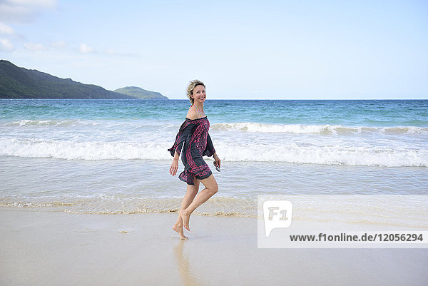 Dominikanische Republik  Samana  glückliche Frau  die am Strand spazieren geht.