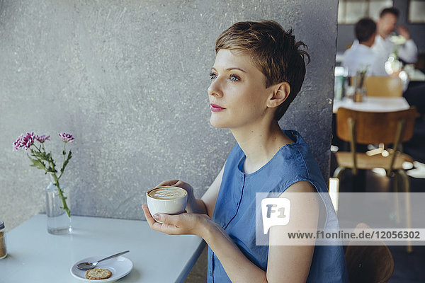 Seriöse Frau mit einer Tasse Kaffee im Cafe