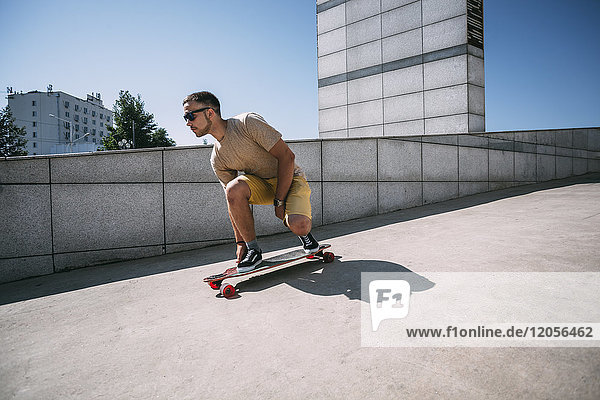 Junger Mann auf dem Skateboard in der Stadt