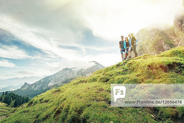 Germany  Bavaria  Pfronten  family enjoying the view on alpine meadow near Aggenstein