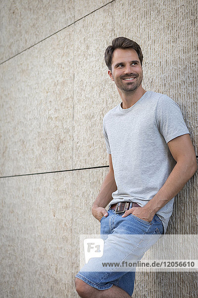 Man leaning against wall  smiling