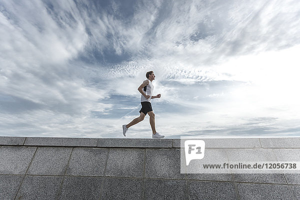 Young man running on wall