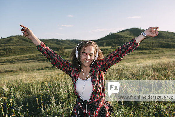 Teenage girl listening music with headphones in nature