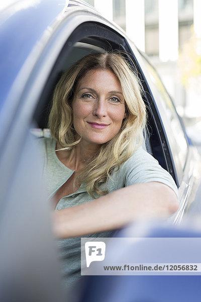 Porträt einer lächelnden Frau im Auto