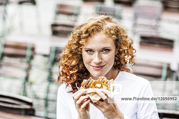 Portrait of smiling young woman with bagel