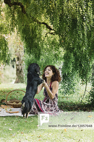 Frau mit Hund beim Picknick im Park