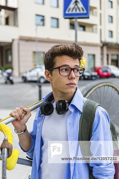 Porträt eines jungen Mannes mit Rennrad auf der Schulter
