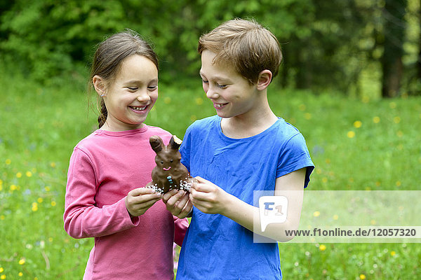 Brother and sister holding chocolate Easter bunny