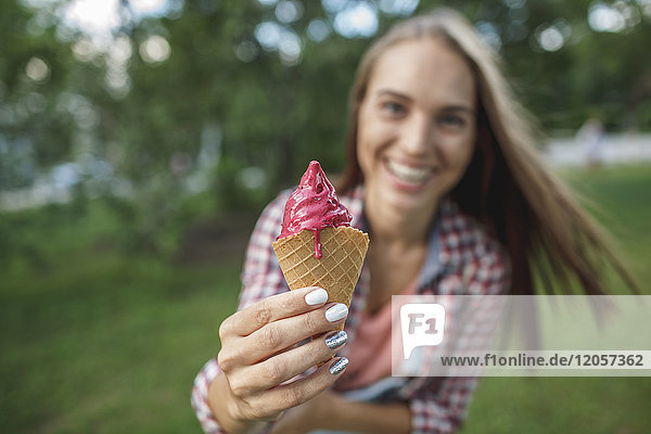 Happy young woman holding ice cream cone