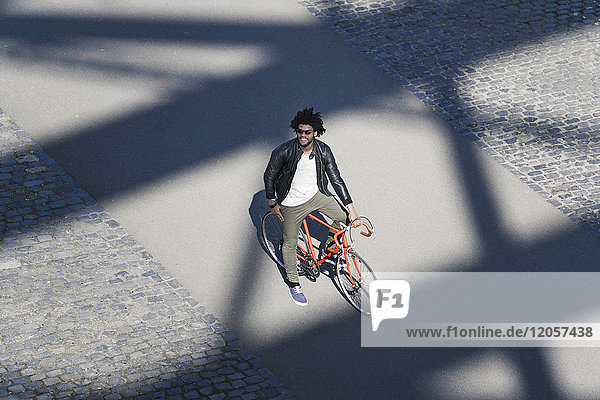 Elevated view of smiling man with sunglasses on bicycle