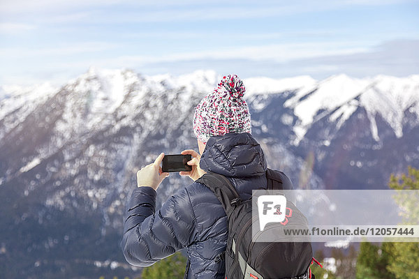 Deutschland  Bayern  Zugspitze  Rückansicht des Mannes beim Fotografieren mit dem Smartphone