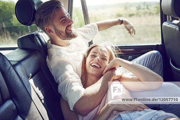 Glückliches junges Paar entspannt im Auto
