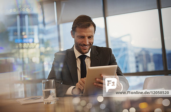 Smiling businessman using digital tablet in conference room