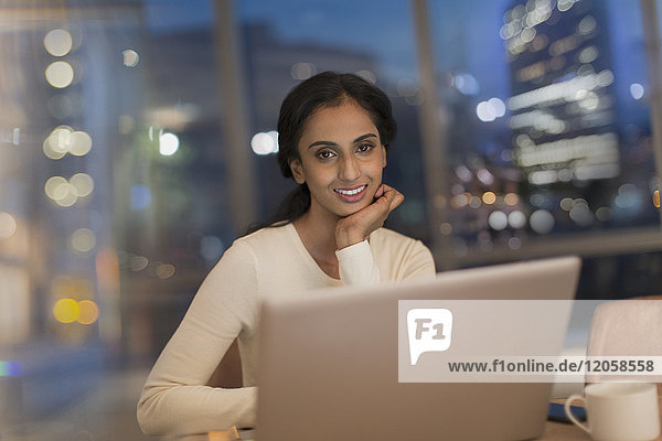 Geschäftsfrau arbeitet nachts am Laptop im Büro