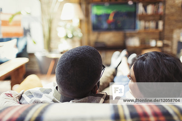 Junges Paar entspannt  fernsehen auf dem Wohnzimmersofa