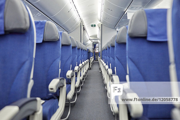 Leere blaue Sitze in einer Reihe im Flugzeug