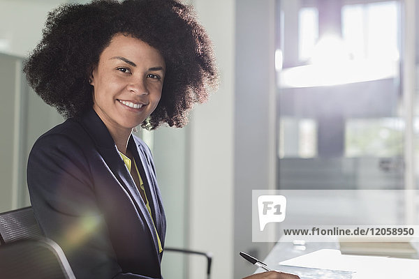Portrait smiling  confident businesswoman working in sunny office