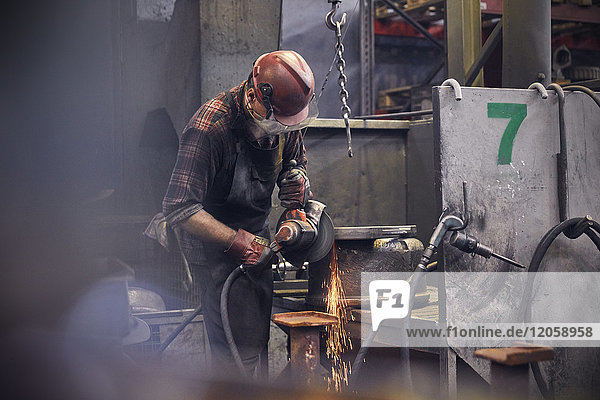 Stahlarbeiter mit Drehmaschine im Stahlwerk