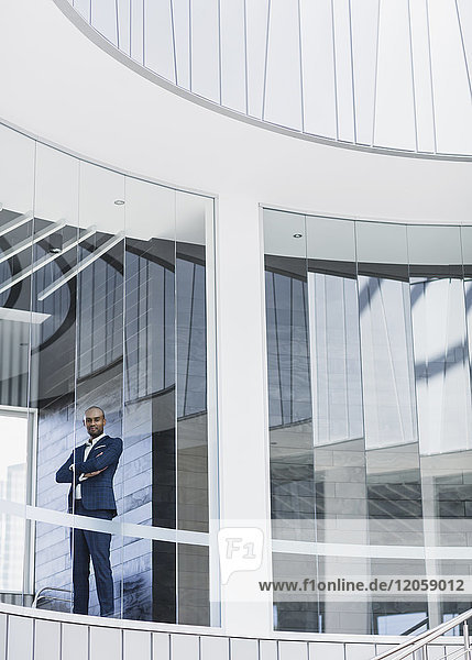 Portrait confident  serious CEO businessman standing at modern office window