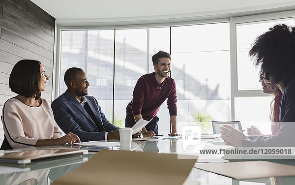 Smiling businessman leading conference room meeting