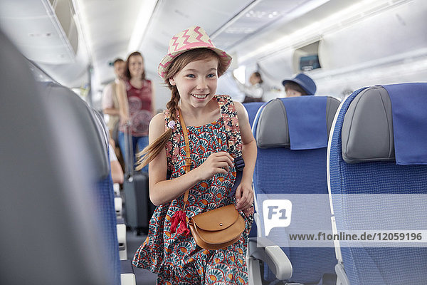 Lächelndes  eifriges Mädchen beim Einsteigen ins Flugzeug