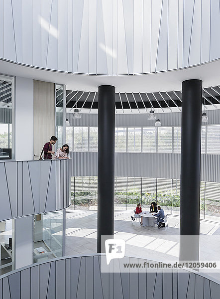 Geschäftsleute treffen sich auf dem architektonischen  modernen Büro-Atrium-Balkon