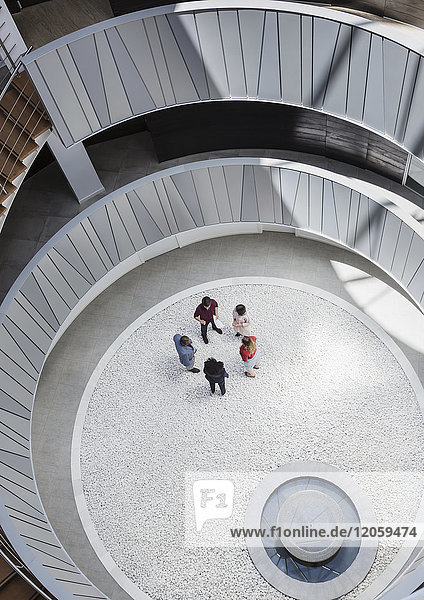View from above business people talking in round  modern office atrium courtyard