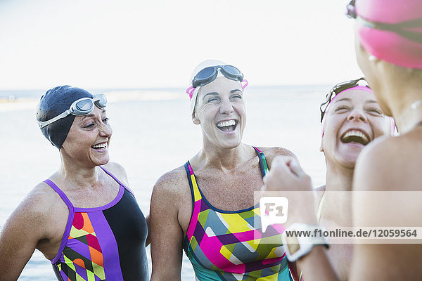 Laughing female open water swimmers talking