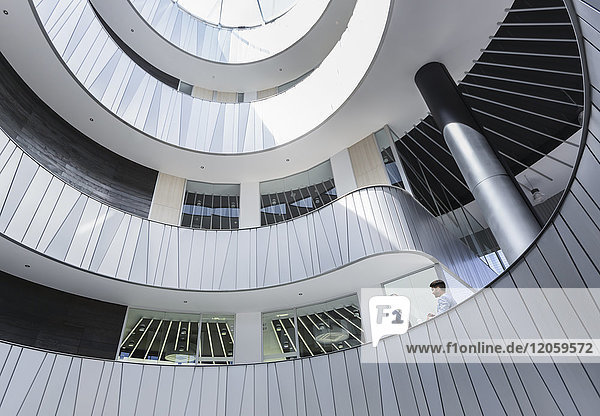 Geschäftsleute im Gespräch auf dem architektonischen  modernen Büro-Atrium-Balkon