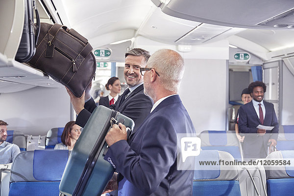Geschäftsleute beim Verladen von Gepäck in den Stauraum des Flugzeugs