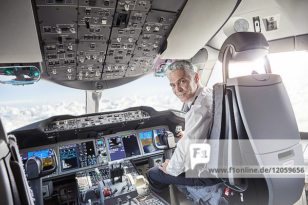 Portrait confident male pilot in airplane cockpit
