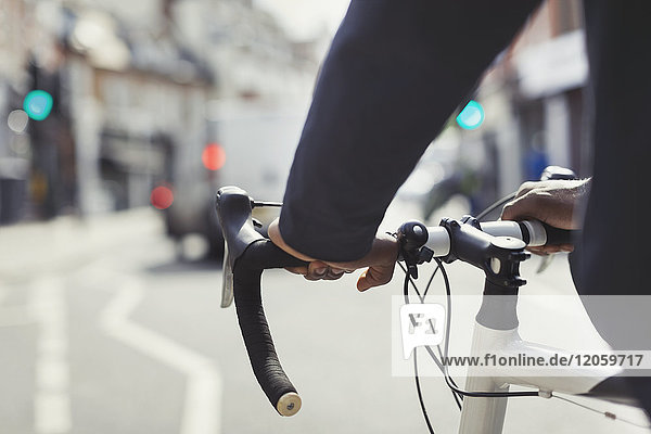 Hands on Man am Fahrradlenker, Pendeln auf sonniger Stadtstraße