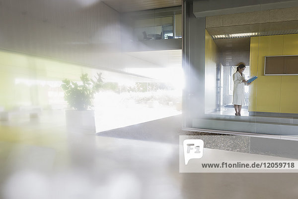 Female scientist standing at window in modern office