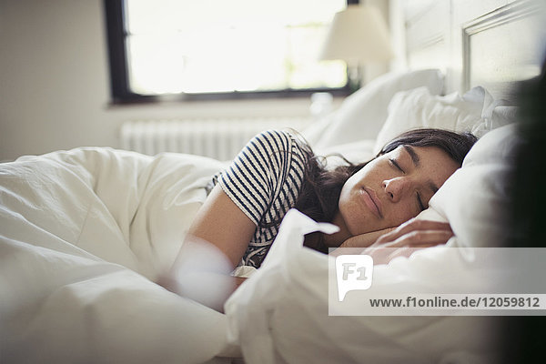 Tired,  serene young woman sleeping in bed