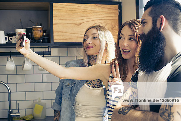 Freunde posieren zusammen für Selfie mit Smartphone